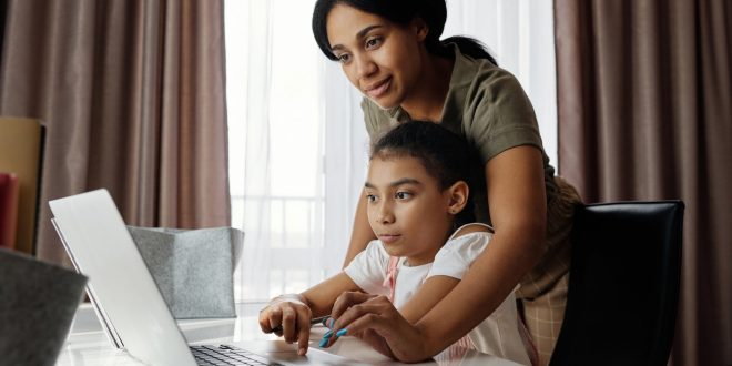 Cheap laptops. Mother helping her daughter use a laptop.