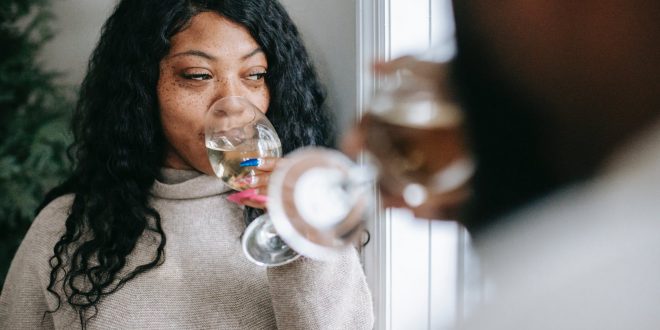AUD. Dreamy black woman with anonymous boyfriend enjoying champagne in house